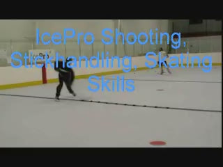 Load video: Kids skating and shooting on a skateable performance-grade synthetic ice at a training surface.